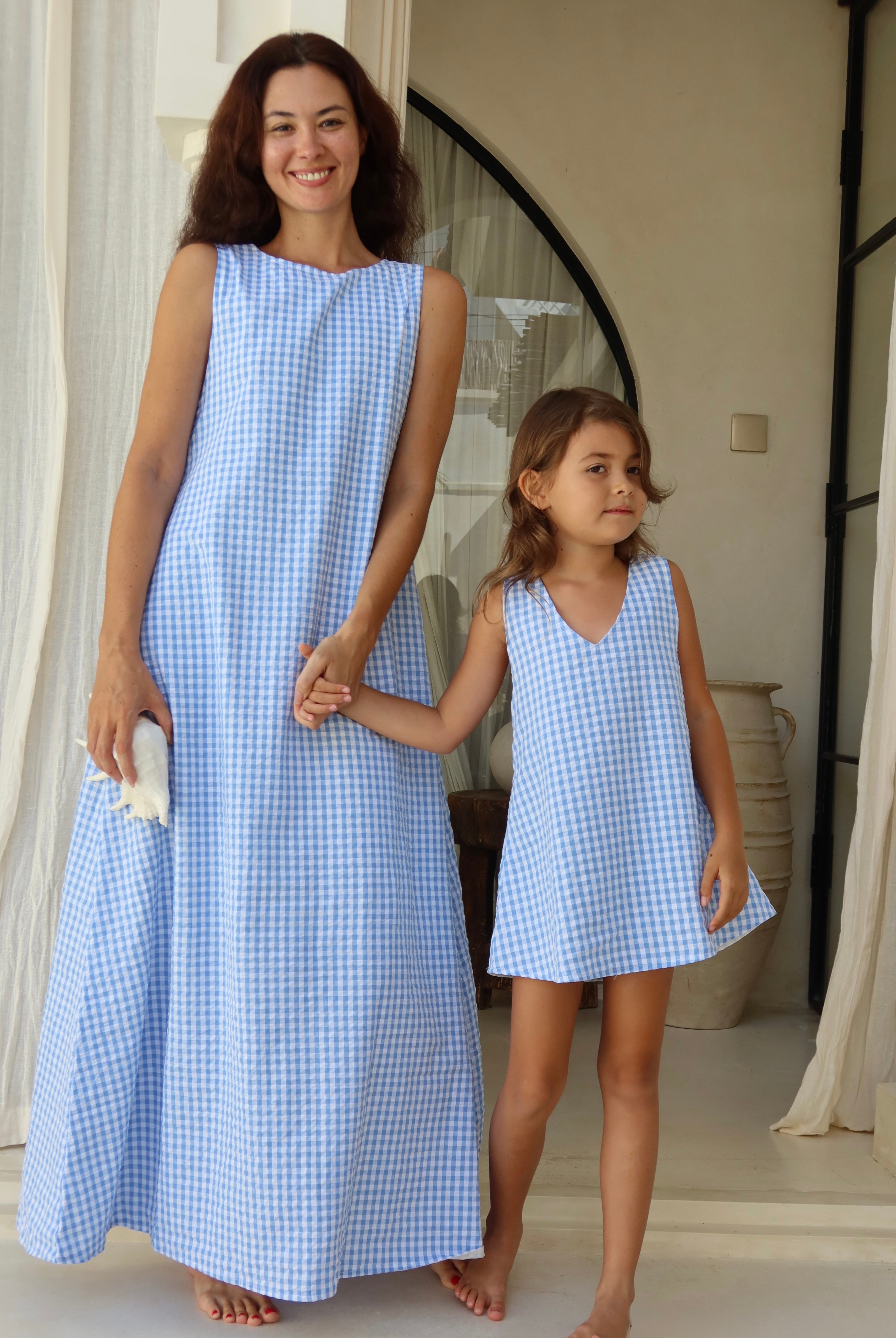 Mommy and me moment in Bali wearing matching summer dresses in light blue gingham.