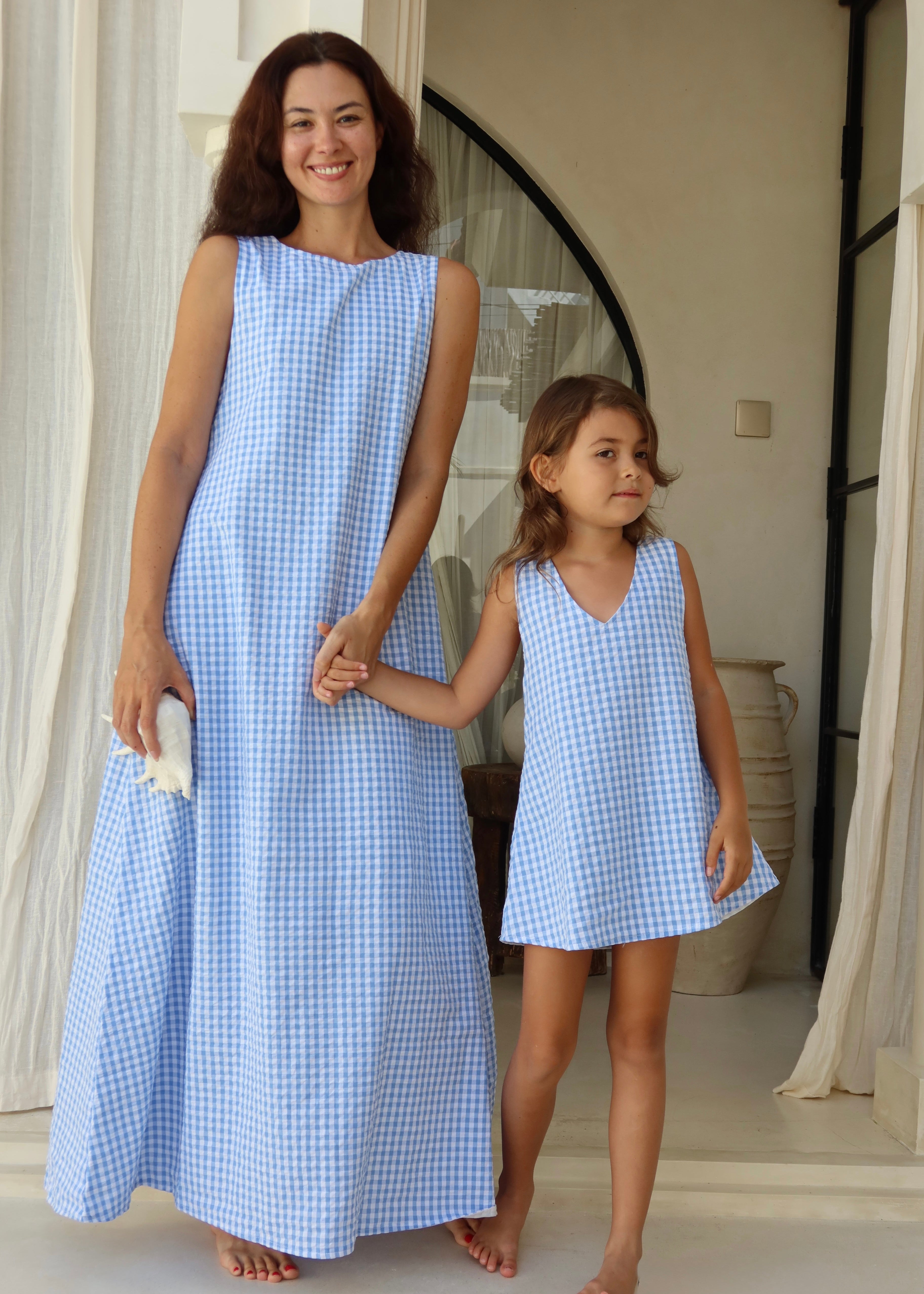 Mommy and me moment in Bali wearing matching summer dresses in light blue gingham.