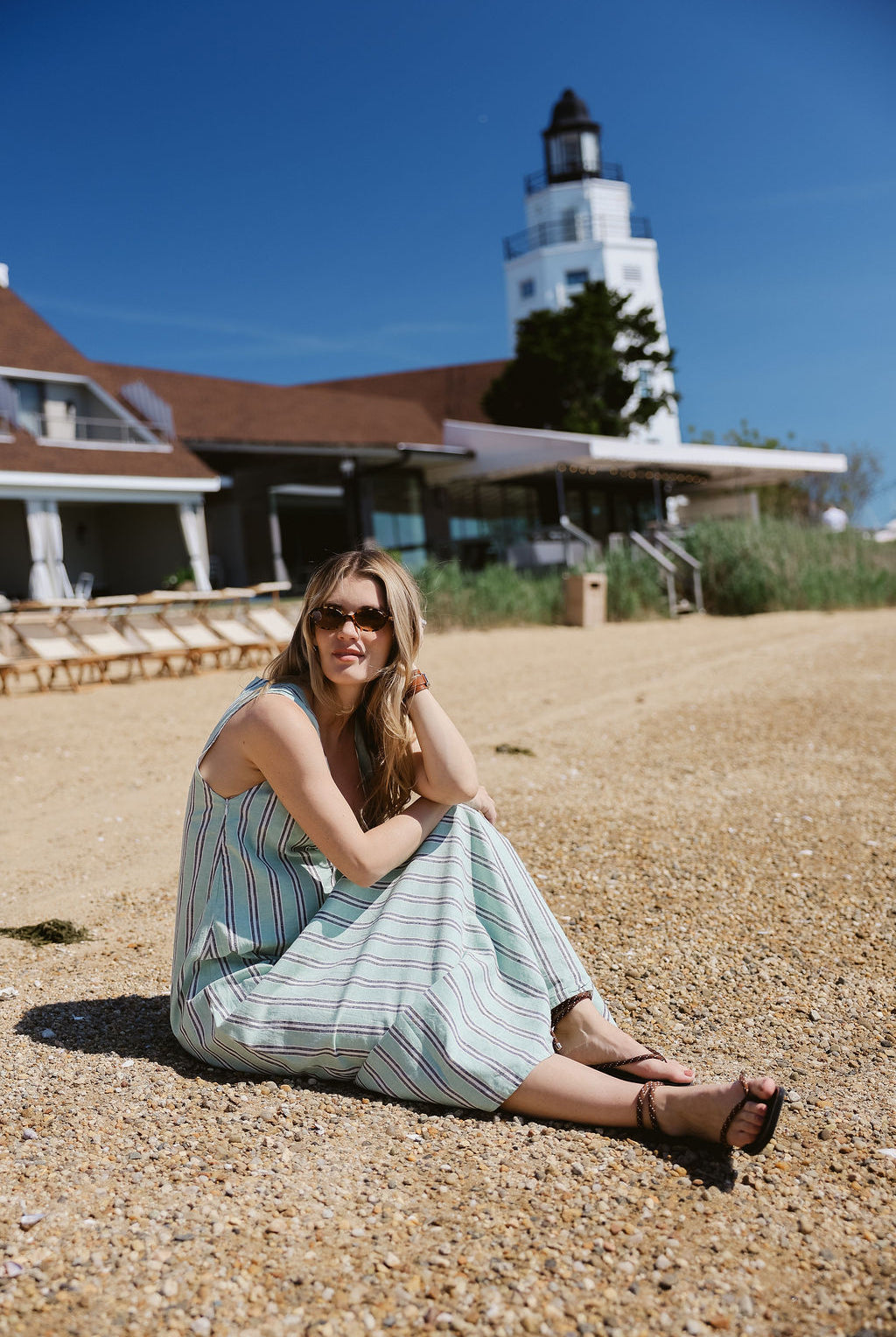 Gili Green Stripe Maxi Dress sitting on pebble beach at Montauk Yacht Club with lighthouse β MTK summer beach dress, Nantucket style stripe maxi dress outfit