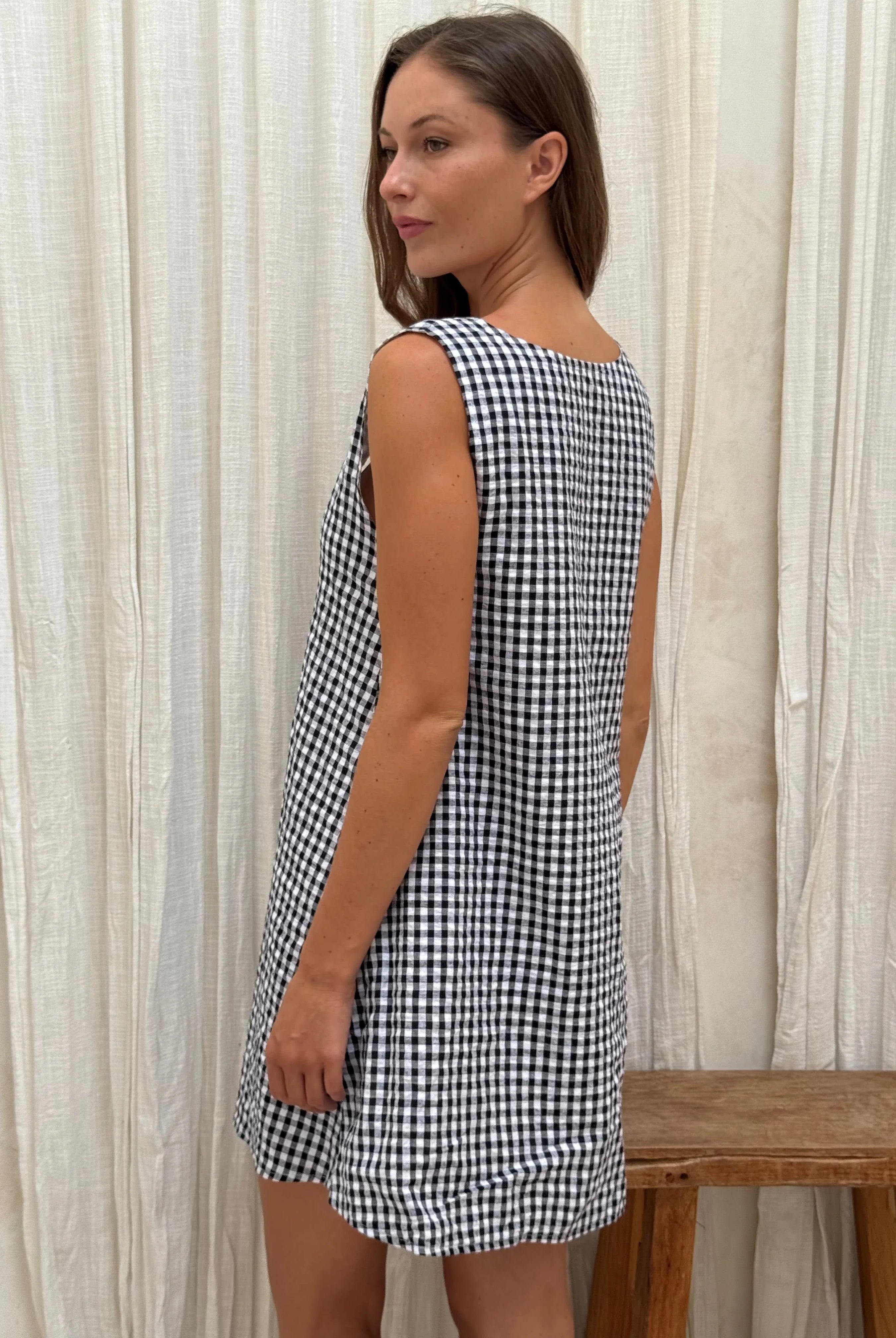 Black gingham mini Gili dress β studio back view of the reversible high neck cotton mini by Puka The Label
