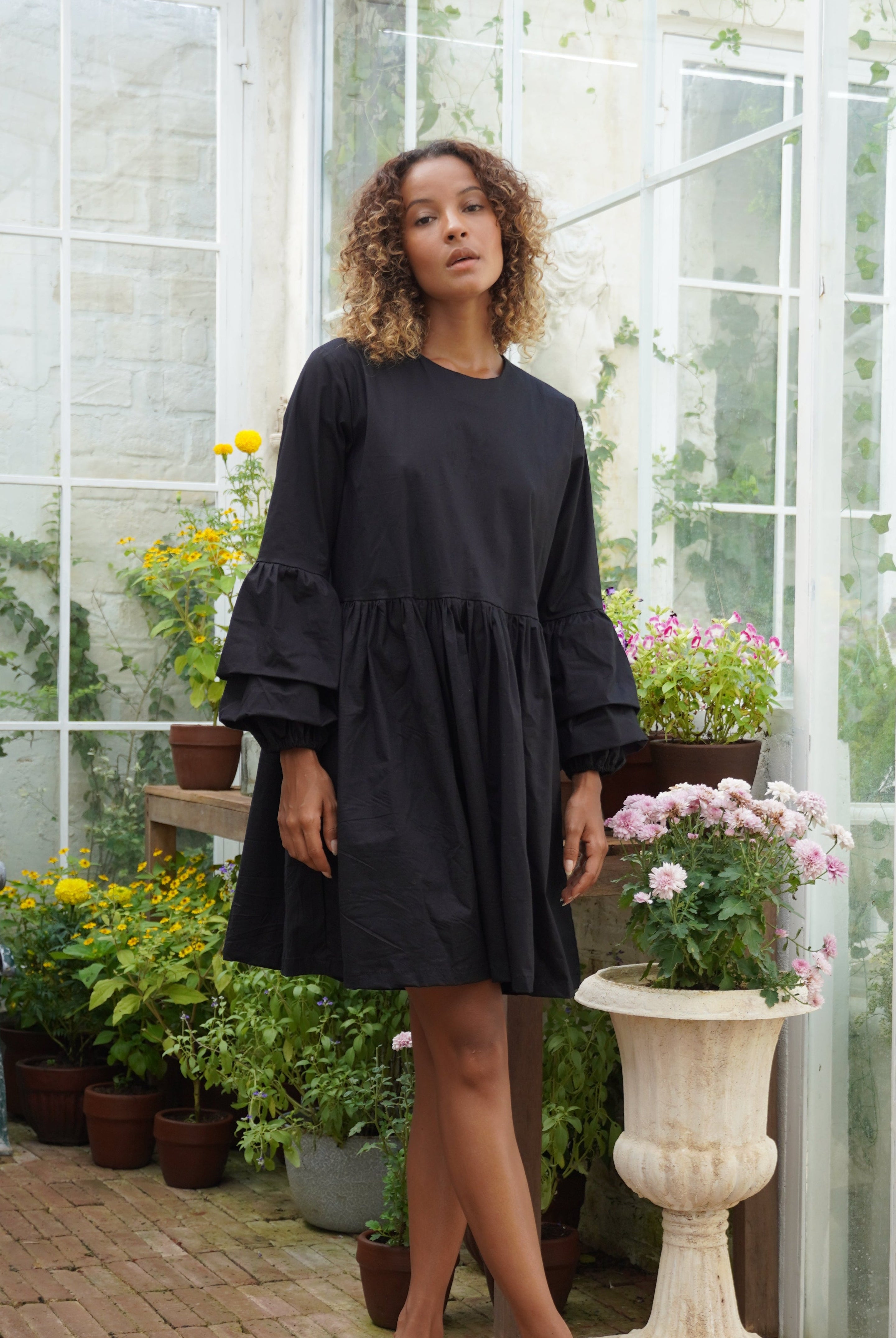 Black ruffle sleeve cotton mini dress rooftop party and date night outfit 2026, oversized button closure Nori Dress Puka The Label