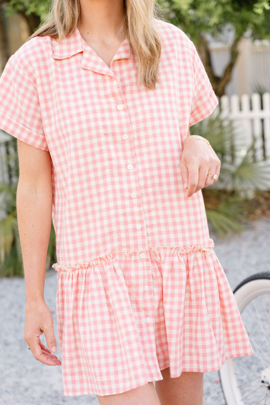 Pink gingham cotton button-up dress resort wear and tropical vacation outfit 2026, effortless feminine mini dress for warm weather travel