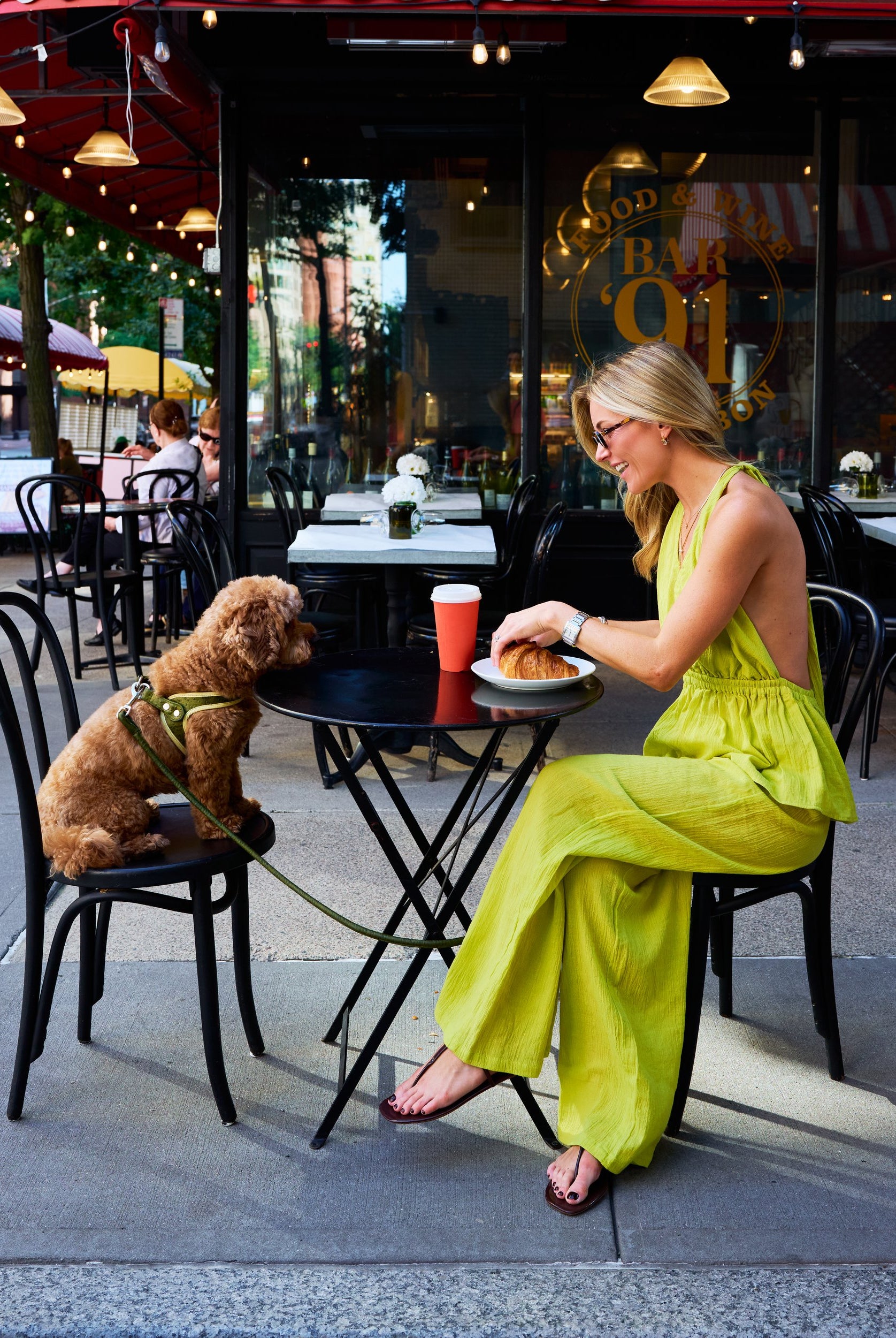 Natalie Simkins in the Puka Carlyle Set Olive Brine at Bar 91 NYC cafe β front view halter top and wide-leg pants