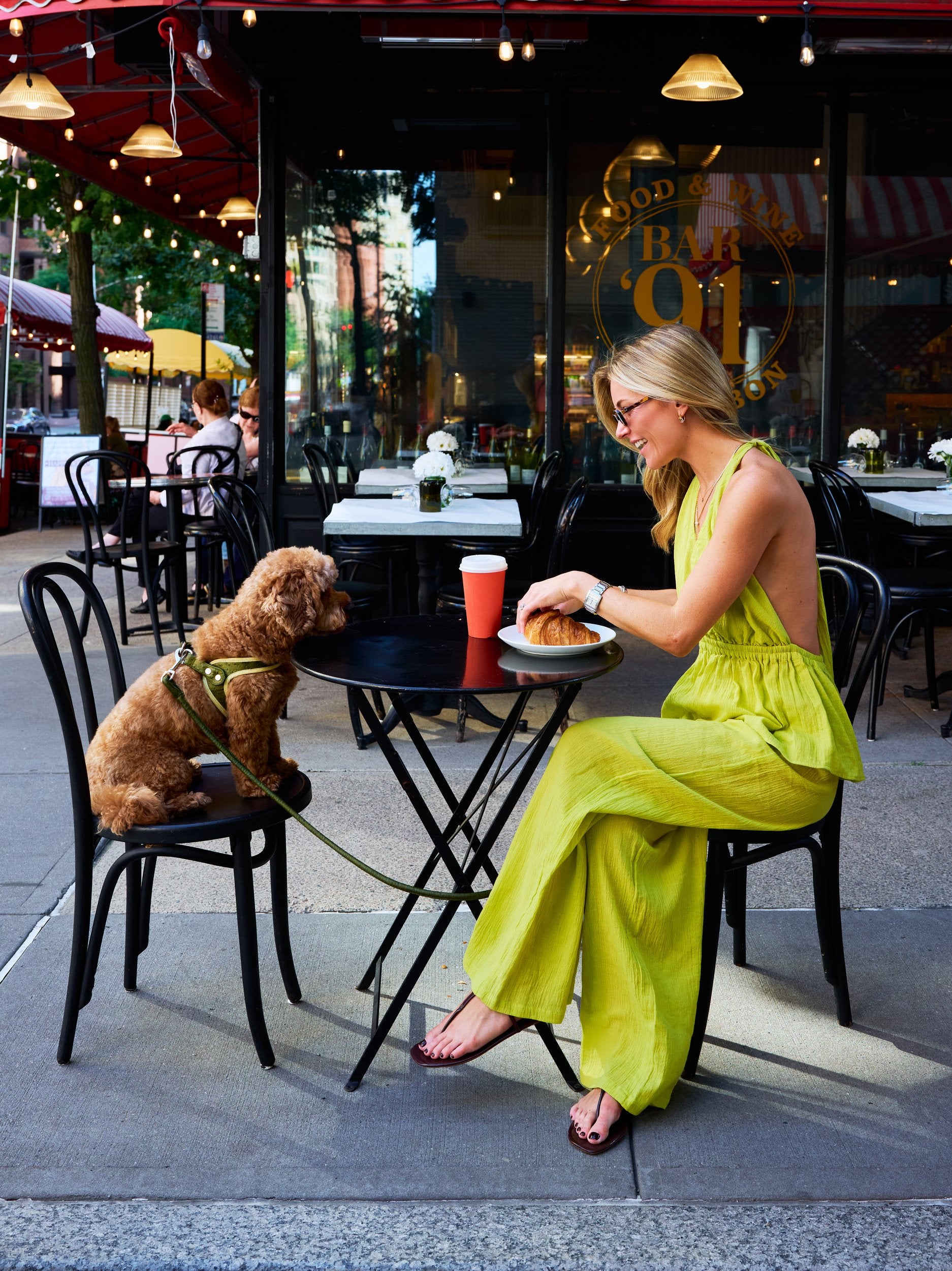 Natalie Simkins in the Puka Carlyle Set Olive Brine at Bar 91 NYC cafe — front view halter top and wide-leg pants