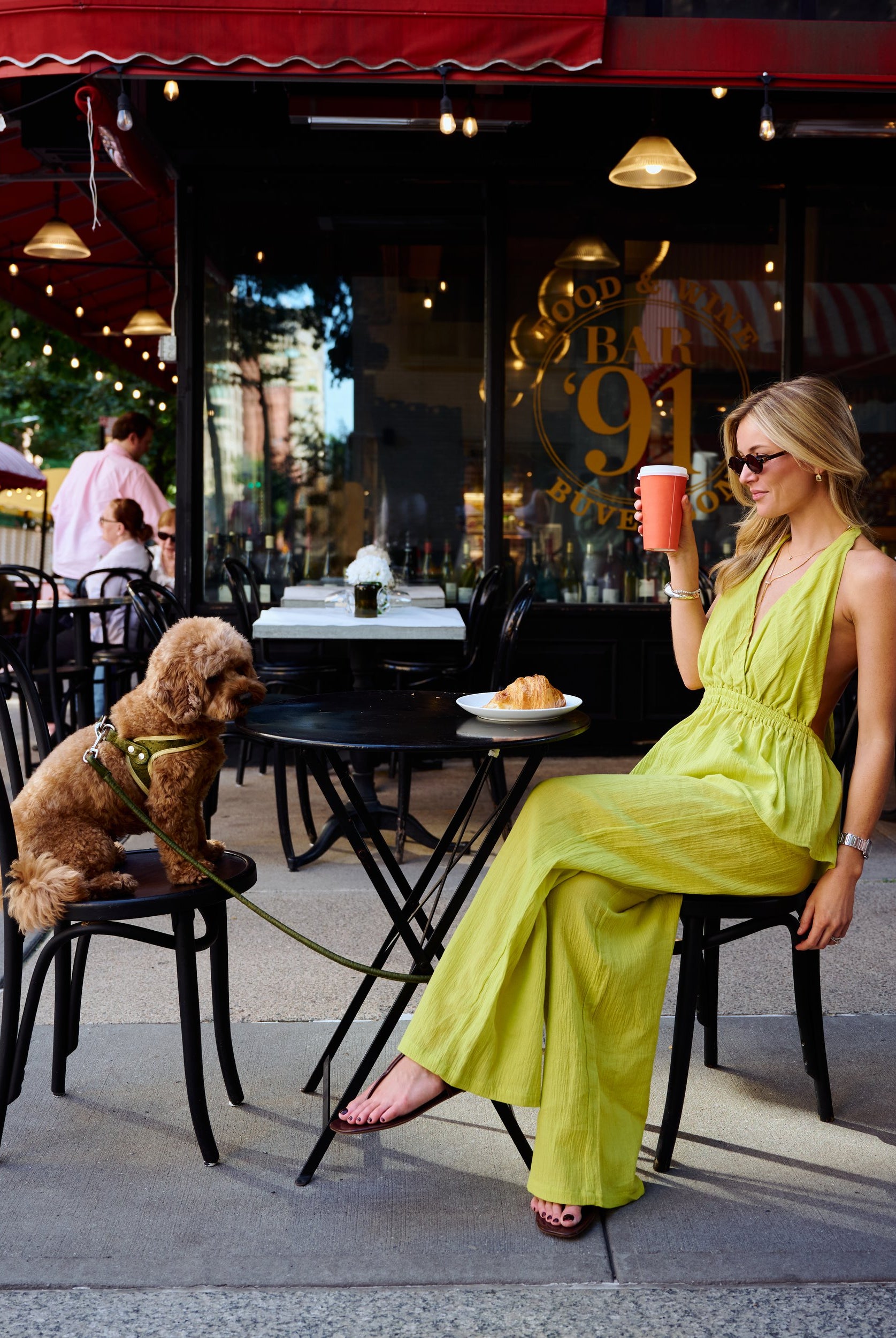 Full view of Puka Carlyle Set Olive Brine at Bar 91 Upper East Side NYC, Natalie seated at cafe