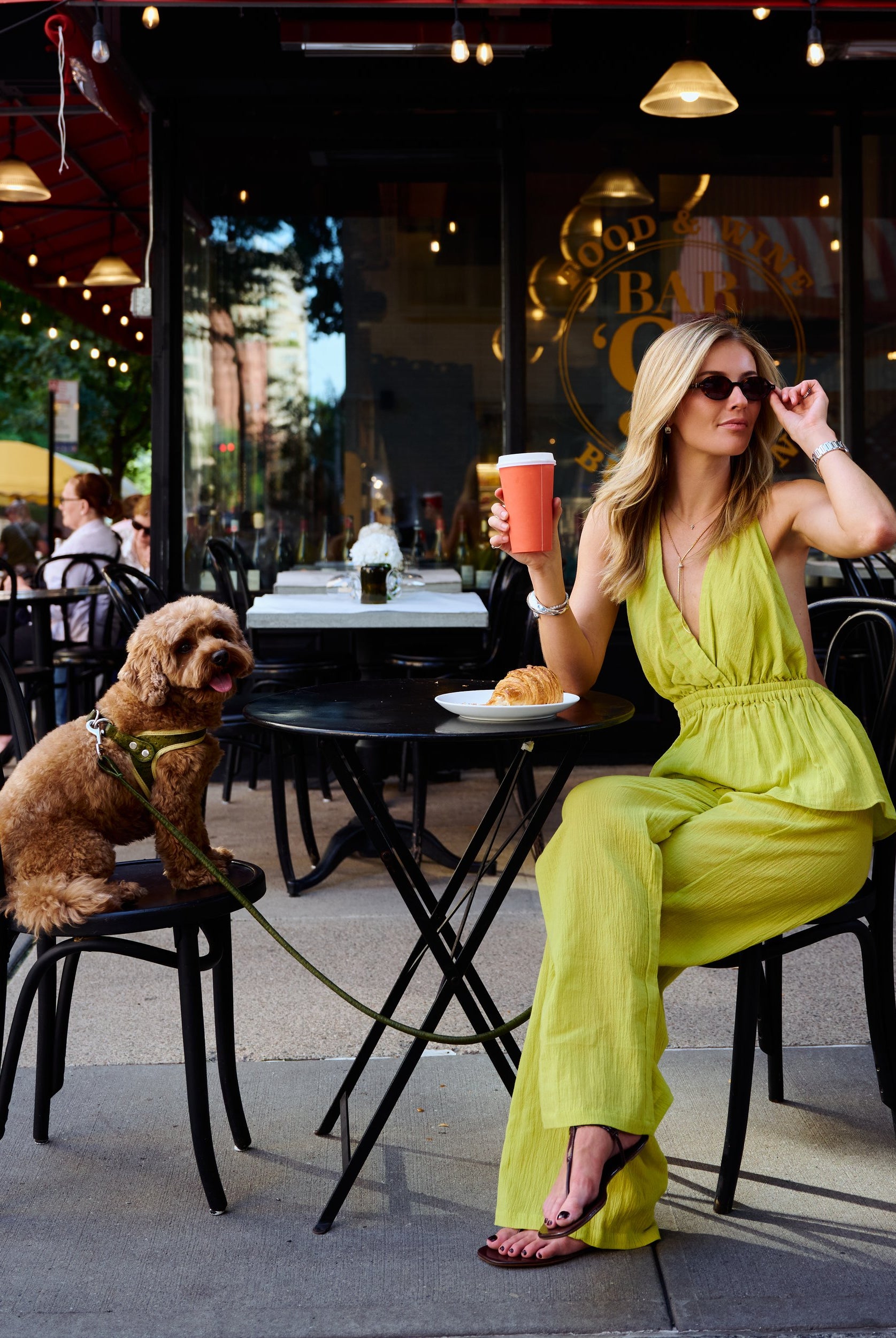 Natalie Simkins in the Carlyle Set Olive Brine at Bar 91 NYC, adjusting sunglasses, full body seated