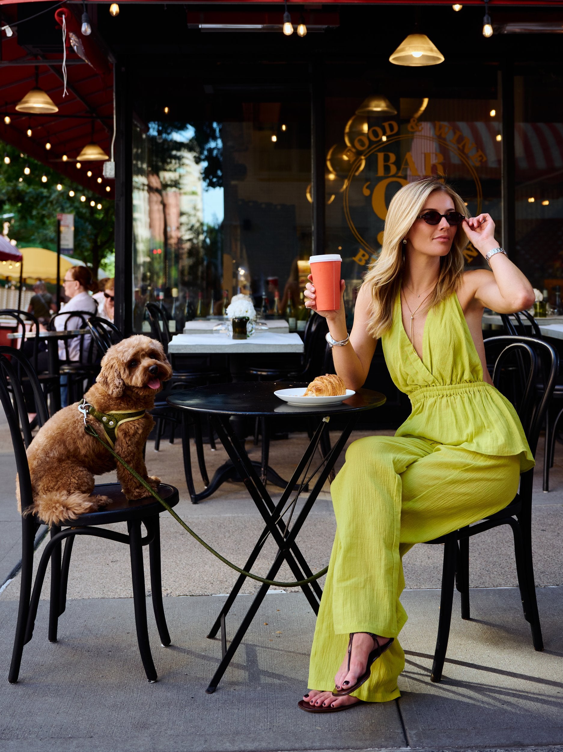 Natalie Simkins in the Carlyle Set Olive Brine at Bar 91 NYC, adjusting sunglasses, full body seated