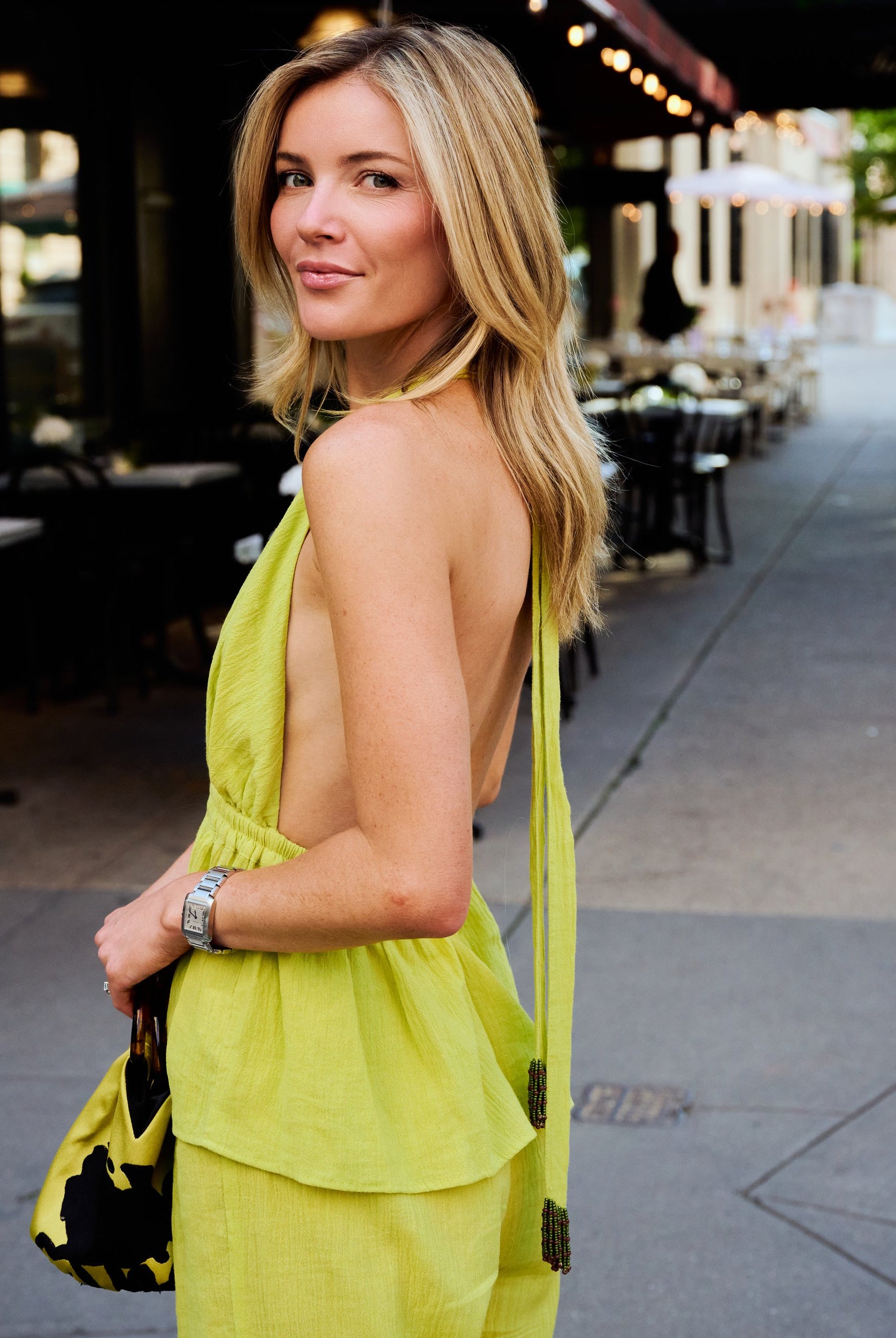 Close-up back detail of Carlyle halter top Olive Brine showing beaded tassel neck tie, NYC sidewalk