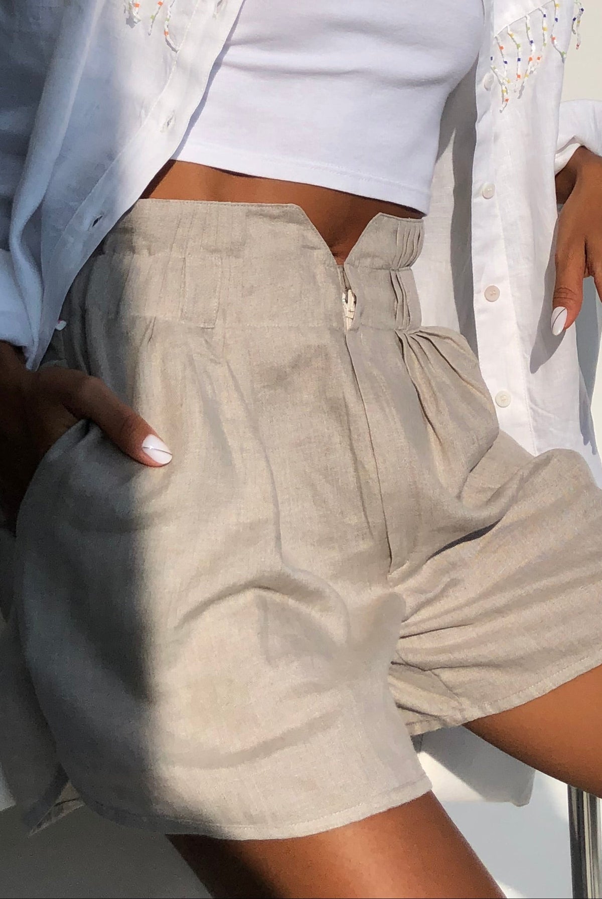 Natural sand linen shorts paired with white Ulu fringe top - coastal beach set outfit for women