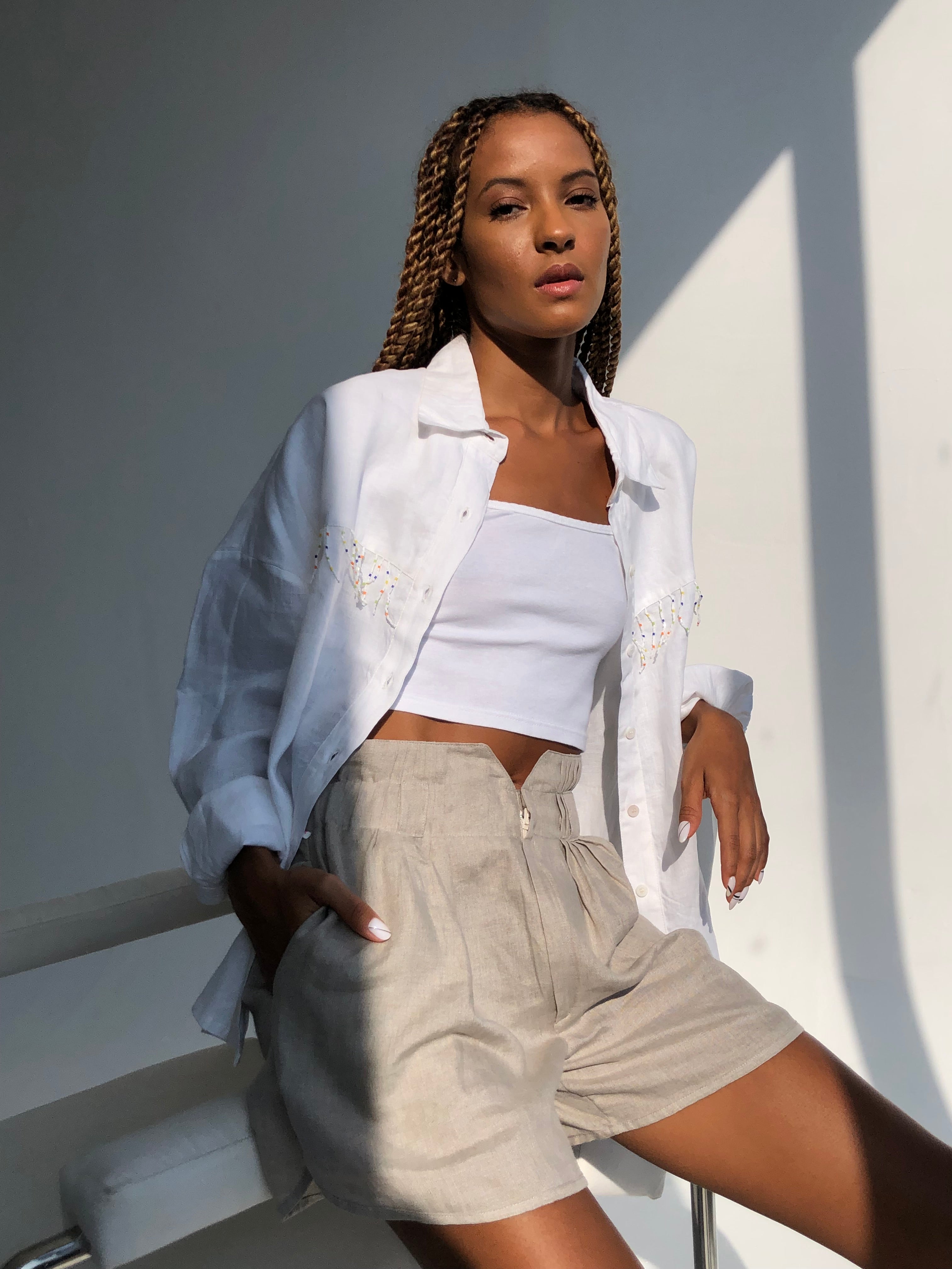 Natural sand linen shorts paired with white Ulu fringe top - coastal beach set outfit for women