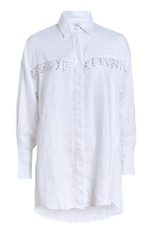 Ulu Dress white linen ghost mannequin flat lay, oversized button-up linen dress with hand-beaded black and white fringe detail 100% linen Puka The Label 2026