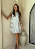 Couper x Puka Exclusive ice blue stripe Mini Gili dress summer outfit 2026, easy to wear textured cotton reversible beach cover-up Puka The Label. Blue, white and brown striped dress