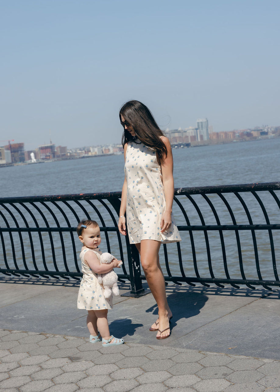 Blue Posey Mini Gili Mommy and Me matching floral dresses at waterfront, mother daughter spring summer 2026 coordinating blue dress Puka The Label