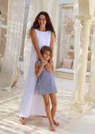 Mom wears white long maxi dress while daughter wears the same style dress but in navy gingham in bali 