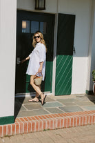 Model opening Montauk Yacht Club door in white linen Ulu Dress and black strappy sandals, East End Hamptons summer outfit MTK 2026 Puka The Label