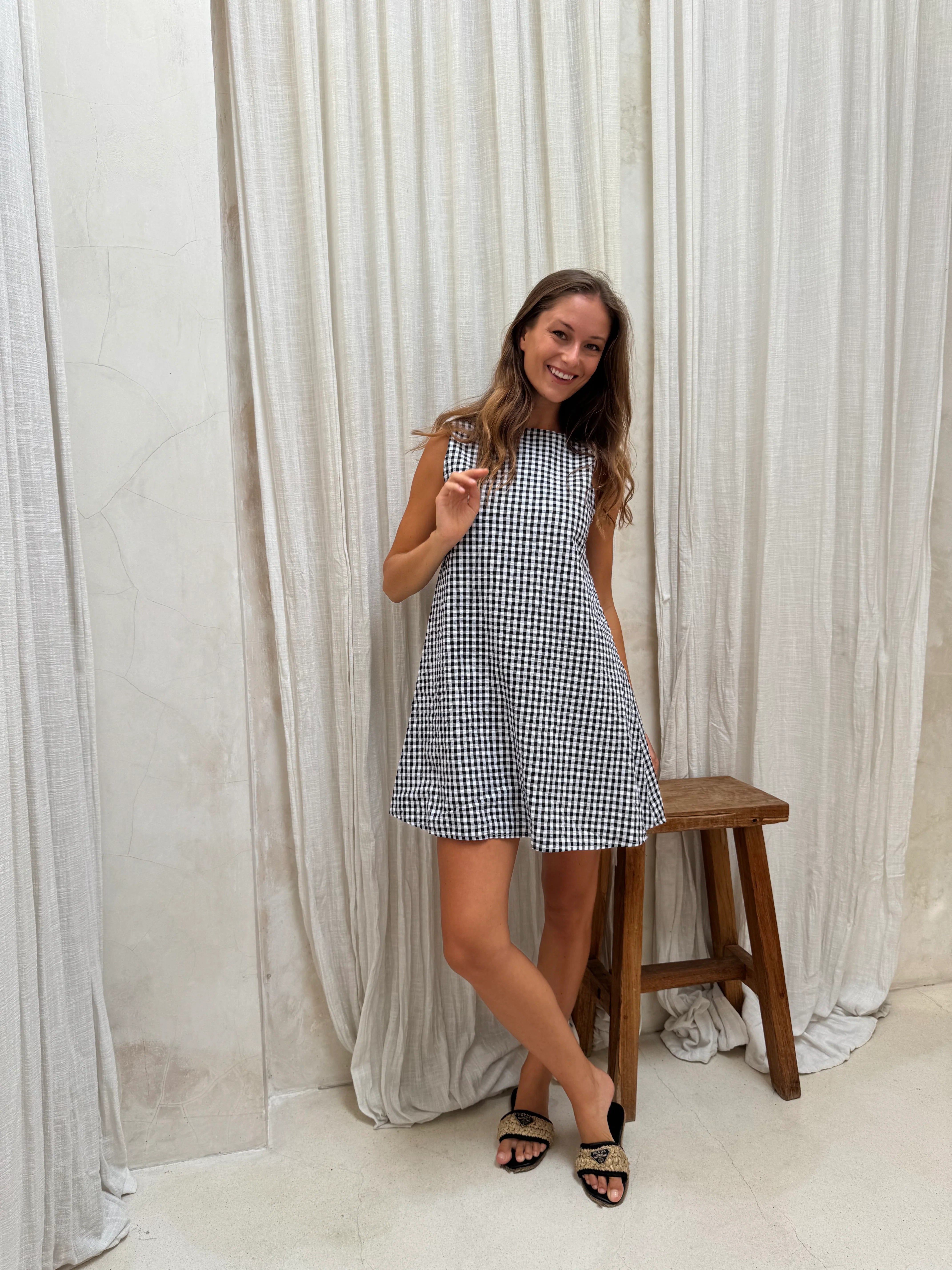 Black gingham mini Gili reversible dress on model — V-neck or high neck cotton mini by Puka The Label