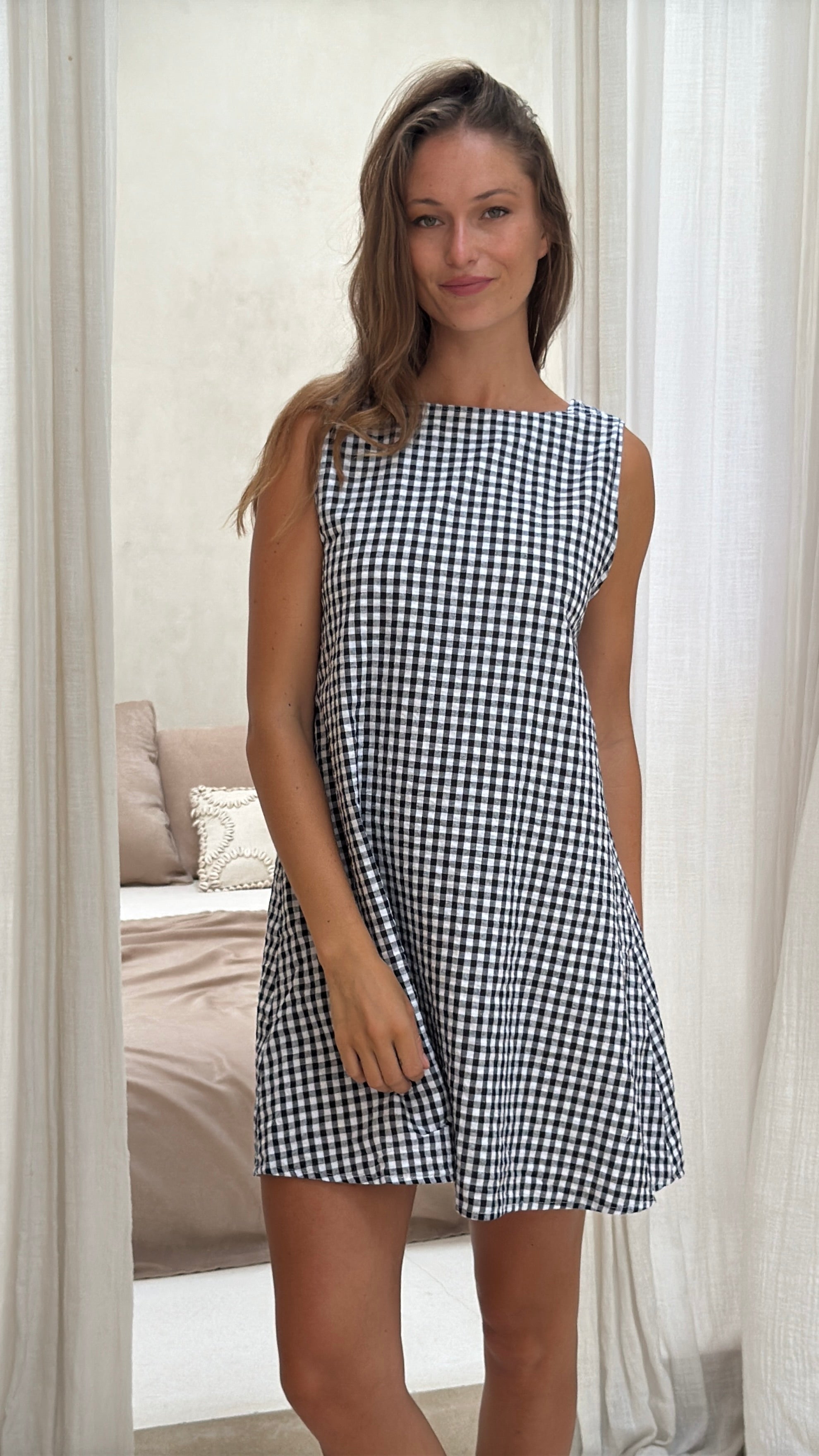 Black gingham mini Gili dress — styled for seamless summer-to-fall transition in reversible cotton by Puka The Label