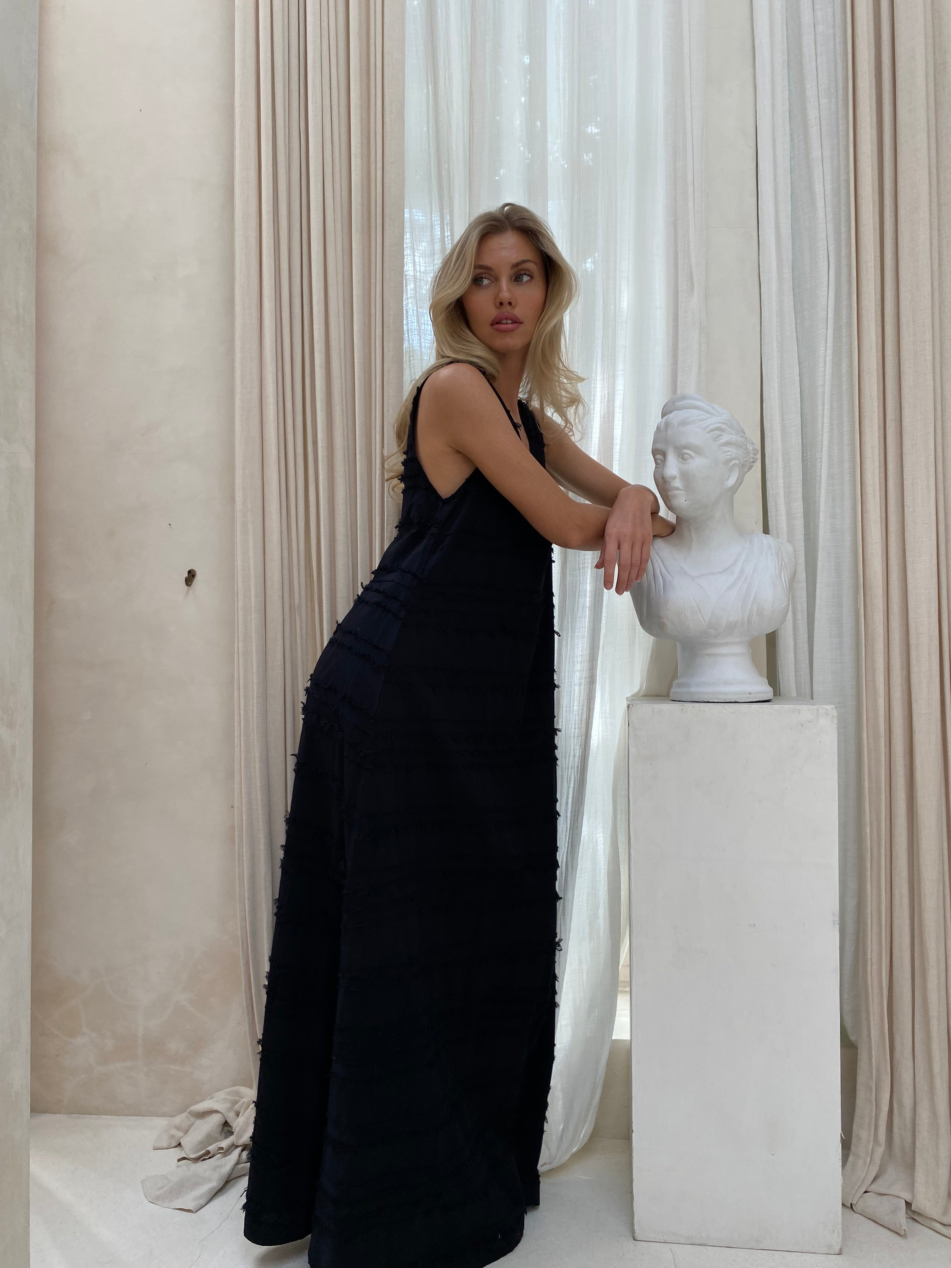 Textured black maxi dress outdoor — chic wedding guest polished city look