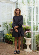 Black oversized cotton mini dress Hamptons rooftop and summer evening outfit 2026, chic ruffle sleeve dress for East Coast coastal occasion