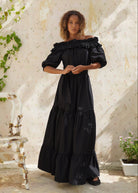 Black off the shoulder maxi dress outdoor wedding guest outfit idea 2026, flowy cotton tiered dress sunlit garden setting