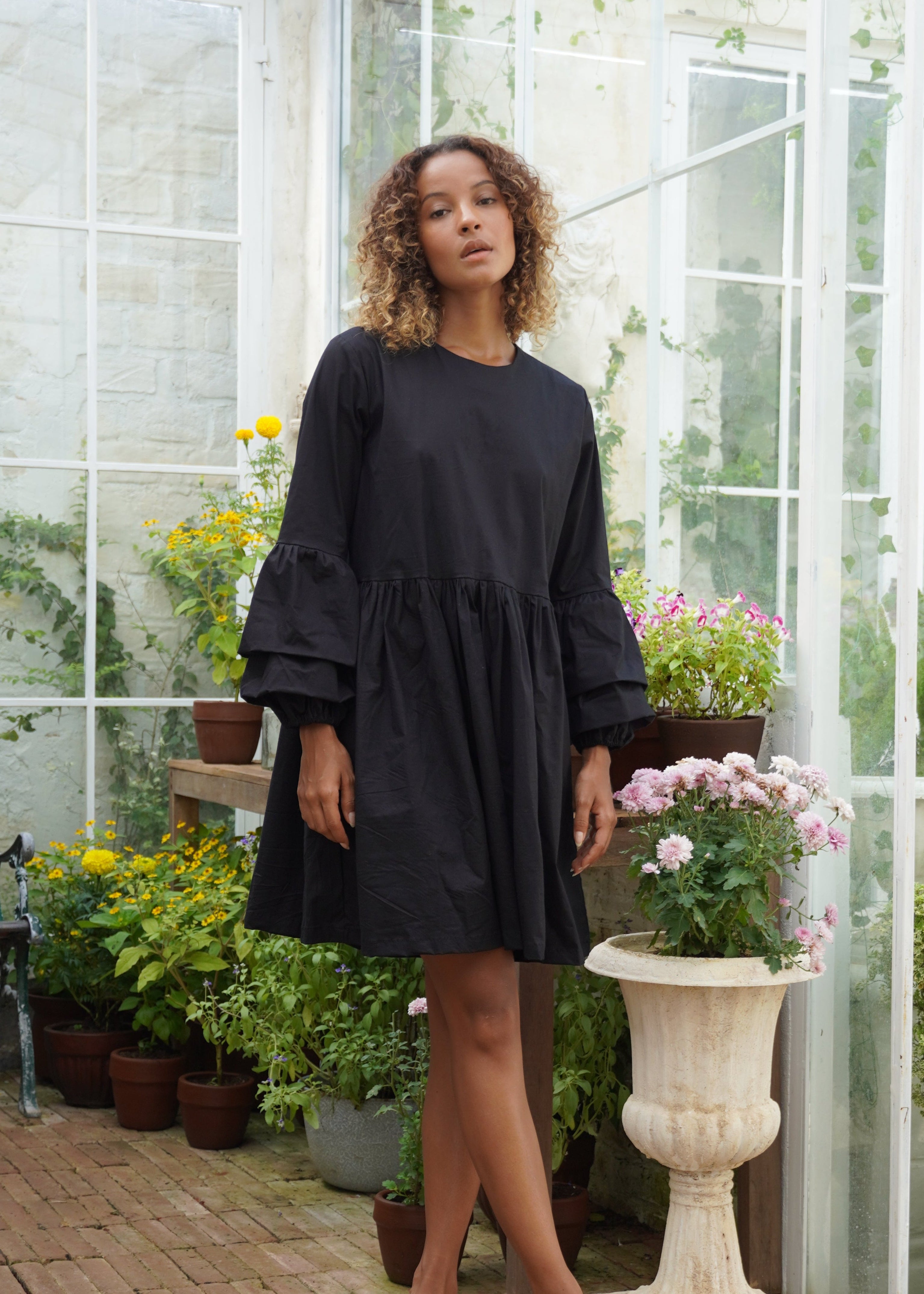 Black ruffle sleeve cotton mini dress rooftop party and date night outfit 2026, oversized button closure Nori Dress Puka The Label
