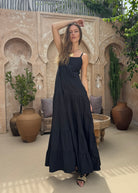 Black tiered cotton maxi dress summer wedding guest outfit 2026, elegant flowy Waverly Dress for outdoor ceremony and coastal celebration Puka The Label