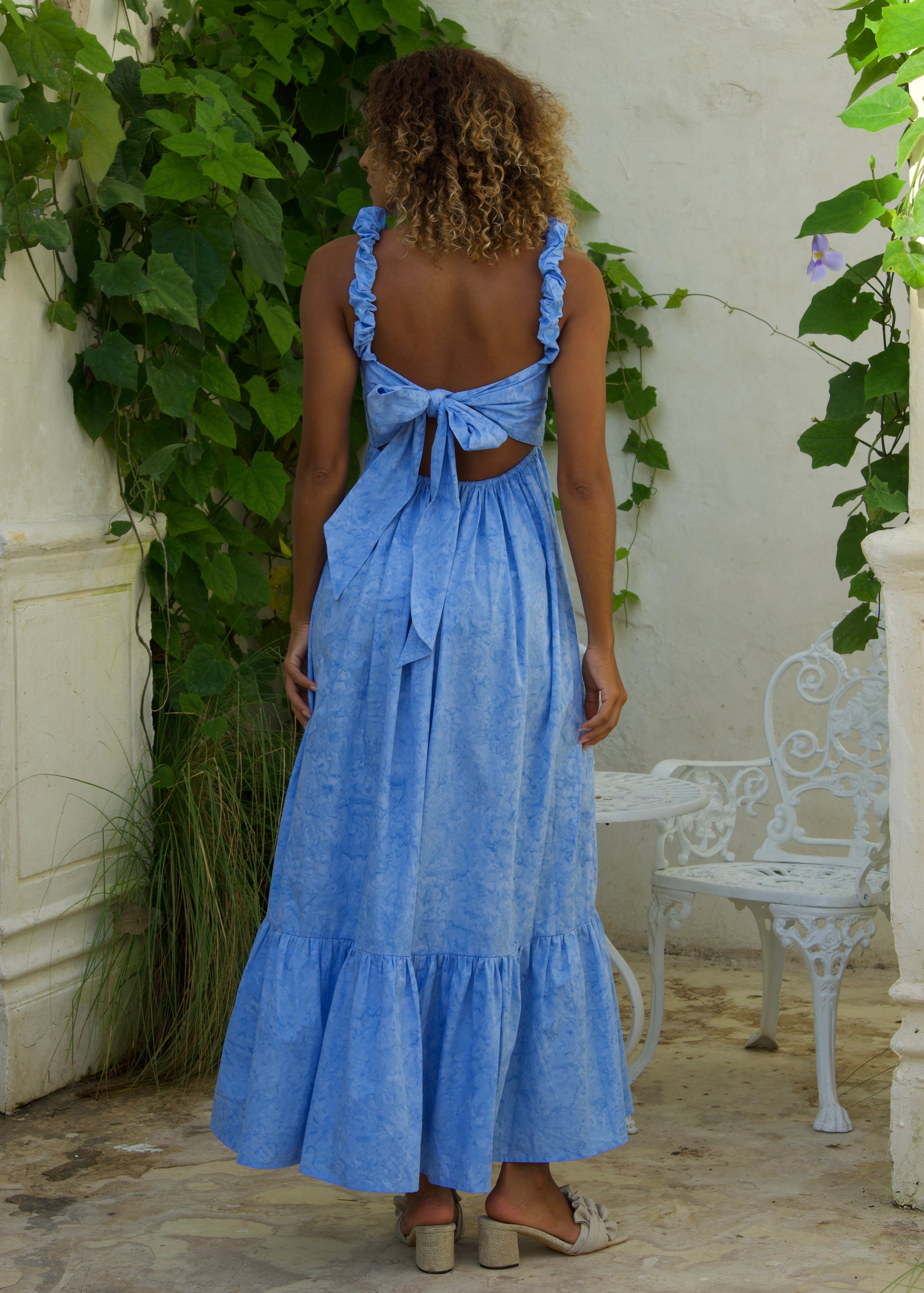 Back view of the Petal Bonito dress showing open-back bow tie — blue cotton ruffle dress for summer parties and bridal showers. Dress with a bow in the back 