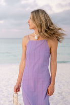 Woman in purple Charli Dress on beach — pearl necklace, hair blowing, summer outfit inspiration for Florida beach vacations
