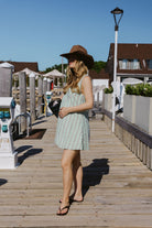 Full-length green stripe Mini Gili hemp cotton dress on Montauk Yacht Club marina dock with raffia hat and flip flops, MTK Hamptons nautical summer outfit 2026