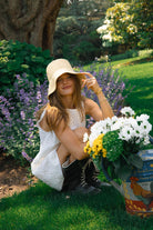 White floral eyelet cotton mini dress Mother's Day outdoor brunch outfit spring 2026, elegant reversible Mini Gili dress for spring celebration Puka The Label. How Hannah Lovey styles a floppy hat and mini white dress out East