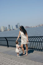 Blue Posey Little Gili kids spring dress Mommy and Me, mother daughter walking along waterfront in matching blue rose print dresses 2026 Puka The Label
