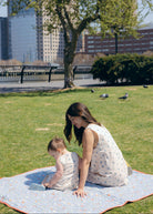 Blue Posey Little Gili girls spring picnic dress, mom and baby in matching blue floral cotton dresses on blanket outdoors Puka The Label