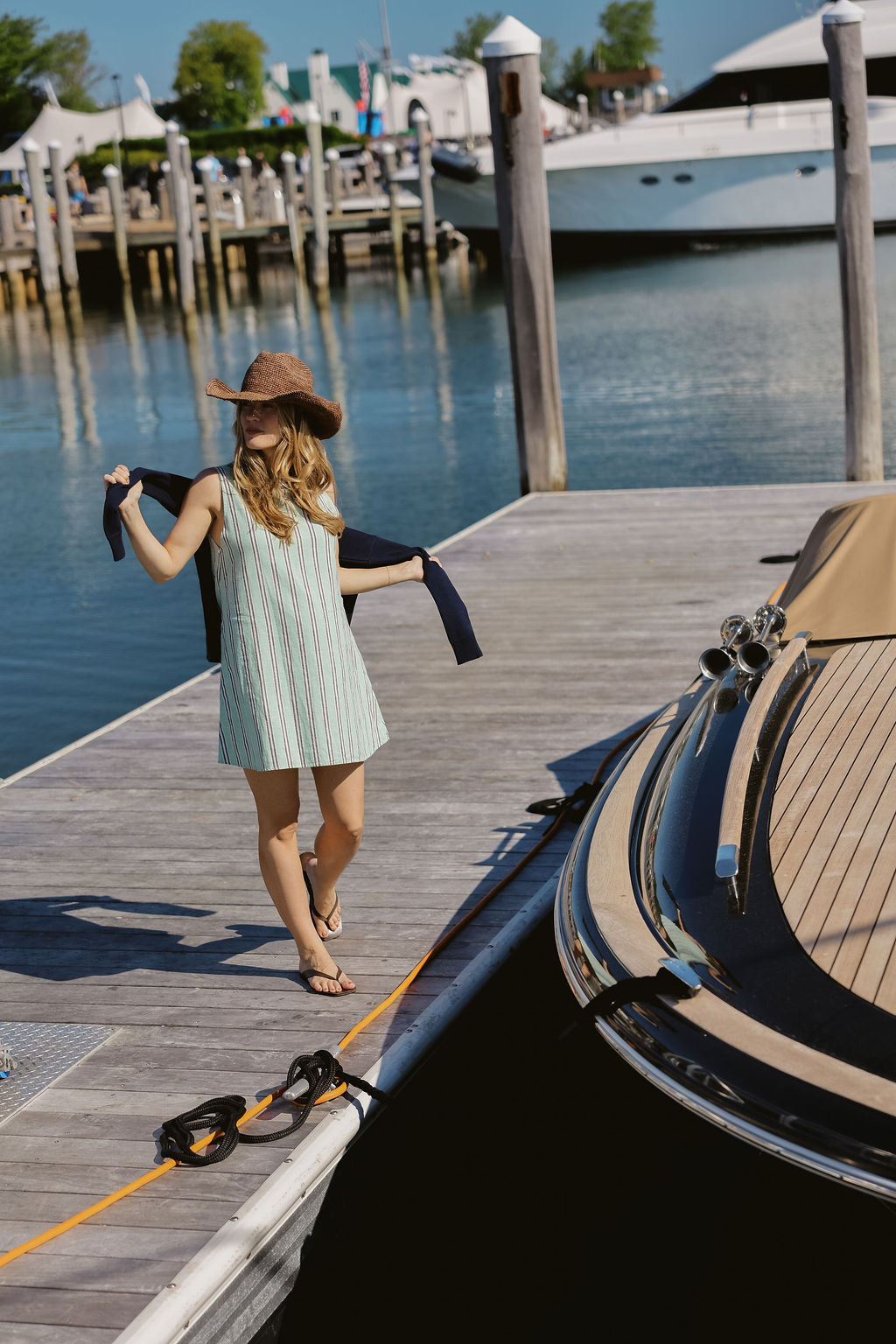 Green stripe Mini Gili mini dress at Montauk Yacht Club dock with luxury yacht moored alongside, preppy nautical MTK Hamptons East End summer outfit 2026