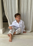 Boy sitting cross-legged in Pantai Polka Dot Pants at a Bali villa, relaxed kids resort wear for beach vacation getaways
