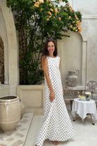 Woman in polka dot maxi dress summer 2026 street style, classic black and white cotton dress for city outing, rooftop party, and warm weather look
