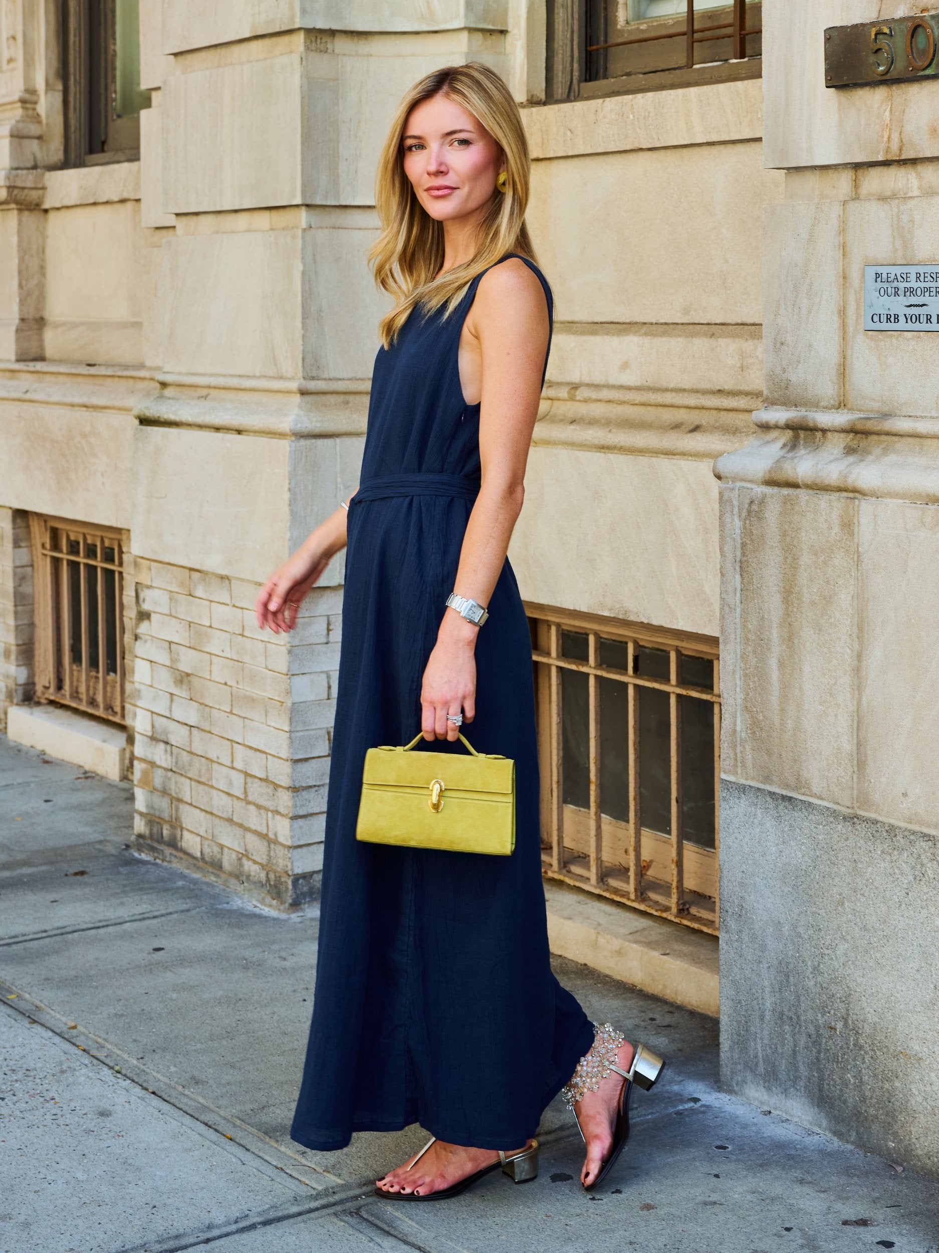 Natalie Simkins in the Puka Camilla Dress Midnight navy — one-shoulder maxi, UES NYC street, chartreuse bag