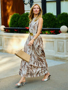 Natalie Simkins wearing the Cleo Brown Zebra maxi dress belted at the waist, walking NYC street