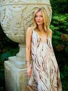 Natalie Simkins in the Cleo Brown Zebra print maxi dress beside a stone garden urn, Central Park NYC