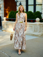 Natalie Simkins in the Puka Cleo in Brown Zebra, flowing maxi silhouette, garden setting