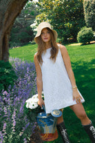 White floral eyelet mini dress 30A and Rosemary Beach spring outfit 2026, feminine cotton Mini Gili dress for Florida Gulf Coast beach vacation. Influencer Hannah Lovey wears a mini in the Hamptons