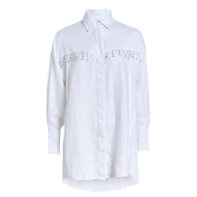 Ulu Dress white linen ghost mannequin flat lay, oversized button-up linen dress with hand-beaded black and white fringe detail 100% linen Puka The Label 2026
