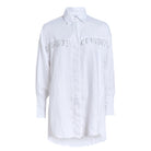 Ulu Dress white linen ghost mannequin flat lay, oversized button-up linen dress with hand-beaded black and white fringe detail 100% linen Puka The Label 2026